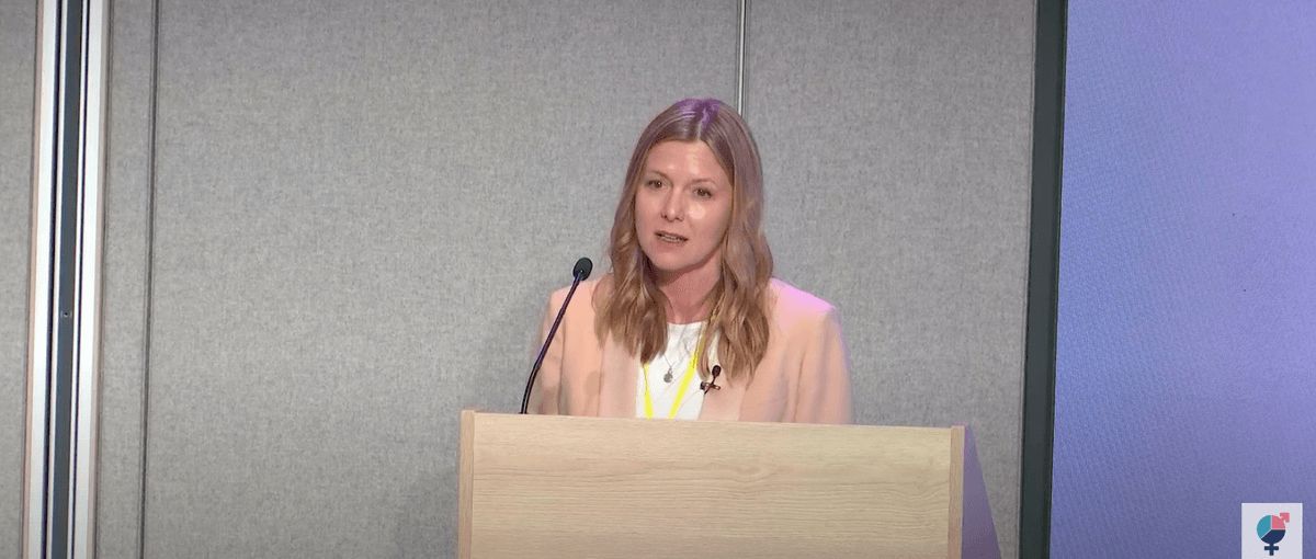 a woman behind a podium speaking into a microphone